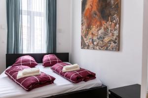 a bed with purple pillows and a painting on the wall at Banksy by prater park close to city centre in Vienna