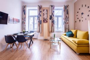 a living room with a yellow couch and a table at Banksy by prater park close to city centre in Vienna