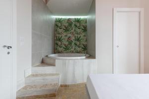 La salle de bains est pourvue d'une baignoire et d'une peinture murale. dans l'établissement Il Sovrano, à Catane