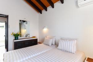 two beds sitting next to each other in a bedroom at Pedras D'el Rei in Tavira