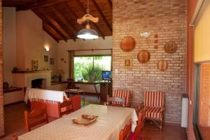 a dining room with a table and chairs and a brick wall at Casa luminosa con pileta ¡ideal para descansar! in Ciudad Lujan de Cuyo