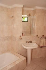 a bathroom with a sink and a bath tub and a sink at Casa luminosa con pileta ¡ideal para descansar! in Ciudad Lujan de Cuyo