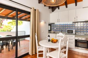 a kitchen and dining room with a table and chairs at Pedras D'el Rei in Tavira