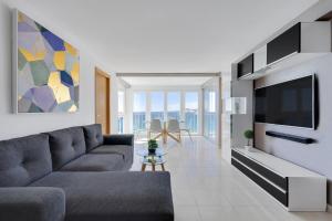 a living room with a couch and a tv at Levante Sunset Front line apartment Almadraba in Benidorm
