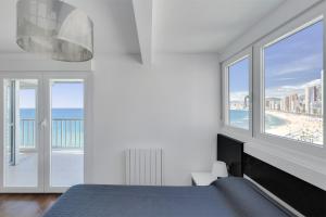 a bedroom with a bed and a large window at Levante Sunset Front line apartment Almadraba in Benidorm