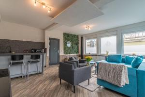 ein Wohnzimmer mit einem blauen Sofa und einer Küche in der Unterkunft Gemütliches Apartment in Neuwied in Neuwied