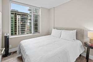 ein Schlafzimmer mit einem weißen Bett und einem Fenster in der Unterkunft Legato Zen Suite by IRIS PROPERTIES! in Victoria