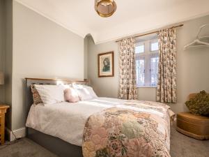 um quarto com uma cama e uma janela em Pass the Keys Charming character lodge in cemetery grounds em Exeter
