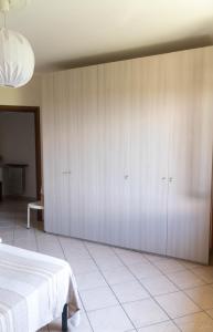 - une chambre avec des placards blancs et un lit dans l'établissement Appartamento per Vacanze Domus Lunae, à Luni