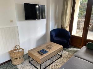 a living room with a couch and a table and a tv at Studio de la mer in La Croix-Valmer