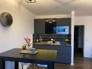 a kitchen with a table and a clock on the wall at BOSTEL 89 - Moderne Stadtwohnung in Moers-Zentrum in Moers