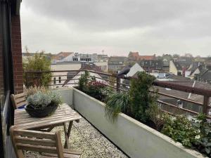 einen Balkon mit einer Holzbank und Pflanzen darauf in der Unterkunft BOSTEL 89 - Moderne Stadtwohnung in Moers-Zentrum in Moers