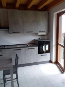 uma cozinha com electrodomésticos de aço inoxidável e uma mesa e cadeira em Residence La Pineta em Serina