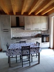 uma cozinha com mesa e cadeiras num quarto em Residence La Pineta em Serina