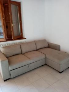 um sofá castanho num quarto com uma janela em Residence La Pineta em Serina