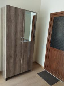 a wooden cabinet with a mirror next to a door at Hotel Vardzia K A L A in Aspindza