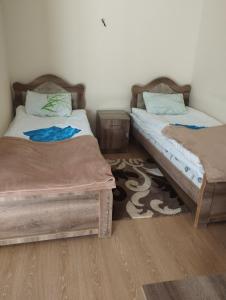 two beds sitting next to each other in a room at Hotel Vardzia K A L A in Aspindza