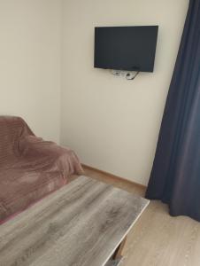 Zimmer mit einem Bett und einem Flachbild-TV an der Wand in der Unterkunft Hotel Vardzia K A L A in Aspindza