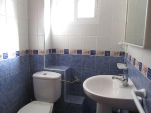 baño azul y blanco con aseo y lavamanos en EXCELENTE APARTAMENTO CON VISTAS AL MAR 6 PLAZAS, en Pontevedra