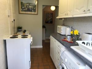 a kitchen with a stove top oven next to a sink at Wye Valley near Tintern Abbey Charming cottage within farmhouse Rocklea Farm,Broadstone, Trellech Monmouthshire in Monmouth