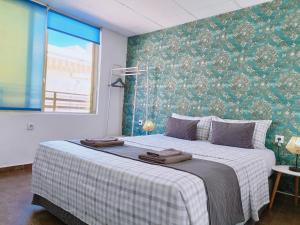 a bedroom with a bed with two towels on it at Gloria Host House in Alicante