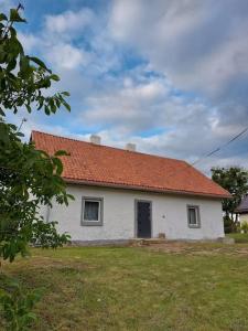una pequeña casa blanca con techo naranja en Dom Podróżnika -aktywne wakacje, en Jabłonowo