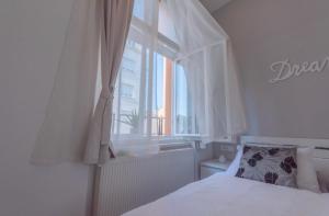 een slaapkamer met een wit bed en een raam bij Main Square Dream Apartment in Zagreb