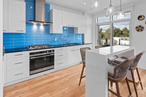 una cucina con armadi bianchi e piastrelle blu di West Bay Topaz by Iris Properties! a Victoria