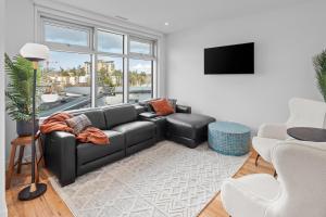 un soggiorno con divano in pelle nera e TV di West Bay Topaz by Iris Properties! a Victoria