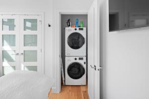 una lavatrice e un'asciugatrice in una stanza accanto a una porta di West Bay Topaz by Iris Properties! a Victoria