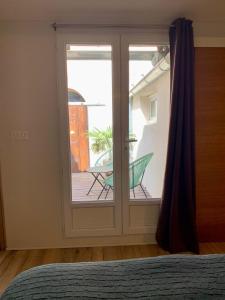 una camera da letto con una porta scorrevole in vetro e un patio di Apartment in the heart of Isle sur la Sorgue a LʼIsle-sur-la-Sorgue