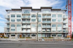 un edificio de apartamentos con una grúa delante en West Bay Topaz by Iris Properties!, en Victoria