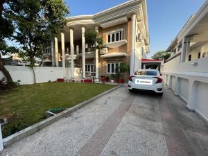 een witte auto geparkeerd voor een huis bij Heritage Inn in Islamabad