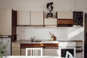 a kitchen with white cabinets and a sink and a stove at Rural Carniola fairytale in Križe +4 photos