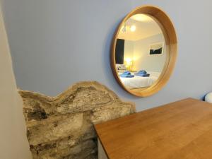 a mirror on a wall next to a table at Llys Bach Apartment at Llys Aeron in Aberaeron