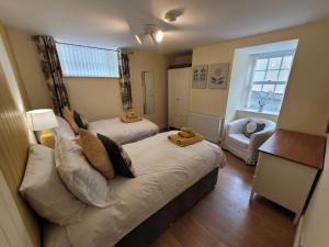 a small bedroom with two beds and a window at Llys Bach Apartment at Llys Aeron in Aberaeron