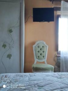 1 dormitorio con silla junto a la cama en Casa vacanza in Casale vicino Orvieto, en Ficulle