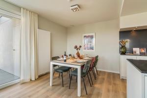 a dining room with a white table and chairs at Orion View - brand new apartment with swimming pool in Nieuwpoort