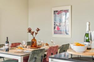 a dining room with a table and chairs with wine bottles at Orion View - brand new apartment with swimming pool in Nieuwpoort