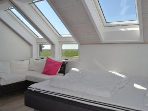 een bed en een bank in een kamer met ramen bij Apartment Drita - 2-3km from the sea in Western Jutland by Interhome in Sønderby
