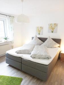 1 cama con sábanas blancas y almohadas en una habitación en Tauchparadies Kreidesee, en Hemmoor