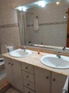 baño con 2 lavabos y espejo grande en El raconet del Riu, en Deltebre