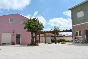 une maison rose avec un arbre devant elle dans l'établissement Casinhas Escondidinho, 