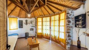salon ze stołem i kilkoma oknami w obiekcie Casa de Piedra La Laguna de Tiscar Puente Genil by Ruralidays w mieście Puente-Genil