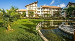 ein Resort mit einem Teich vor einem Gebäude in der Unterkunft Taiba Beach Resort - Apt Duplex Novo in Taíba