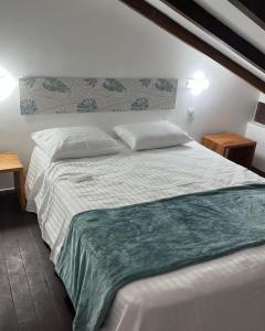 een slaapkamer met een wit bed met 2 kussens bij Taiba Beach Resort - Apt Duplex Novo in Taíba