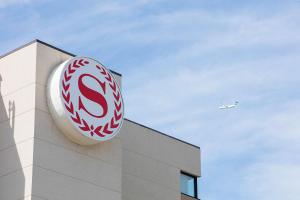 acedes benz sign on the side of a building with an airplane at Sheraton Cavalier Calgary Hotel in Calgary