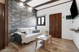 uma sala de estar com um sofá e uma parede de tijolos em Villa Luisa en Frontera em Tigaday