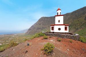 a lighthouse on top of a hill with the ocean at Villa Luisa en Frontera in Tigaday