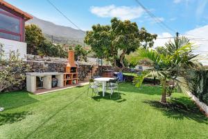 a small garden with a table and chairs on the grass at Villa Luisa en Frontera in Tigaday